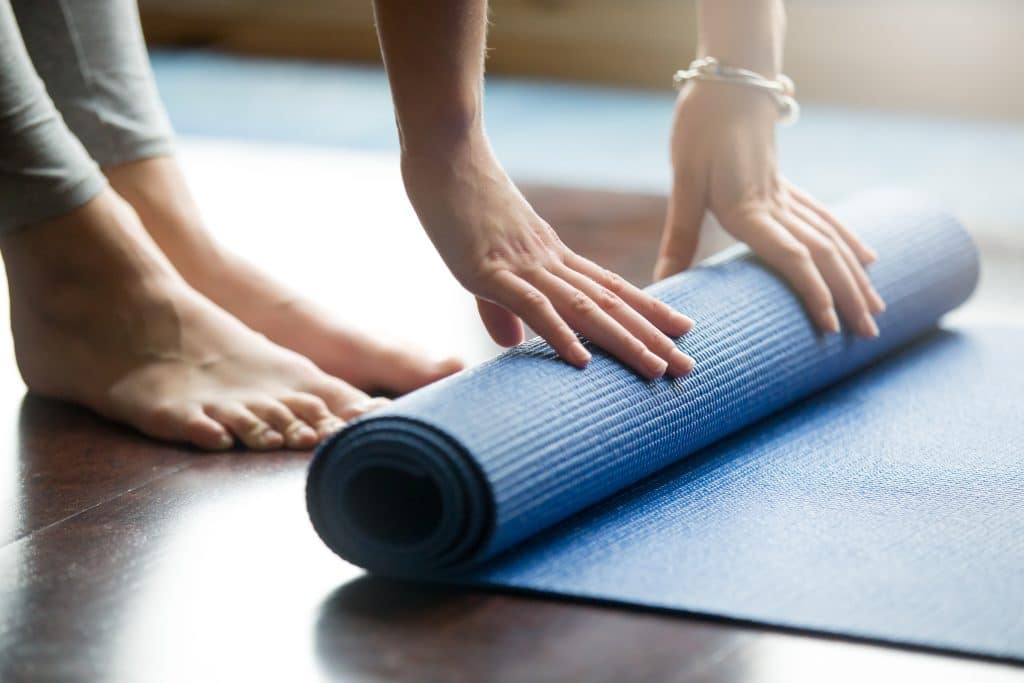 a person rolling a yoga mat