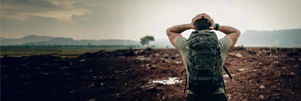 a man with a backpack looking at a tree