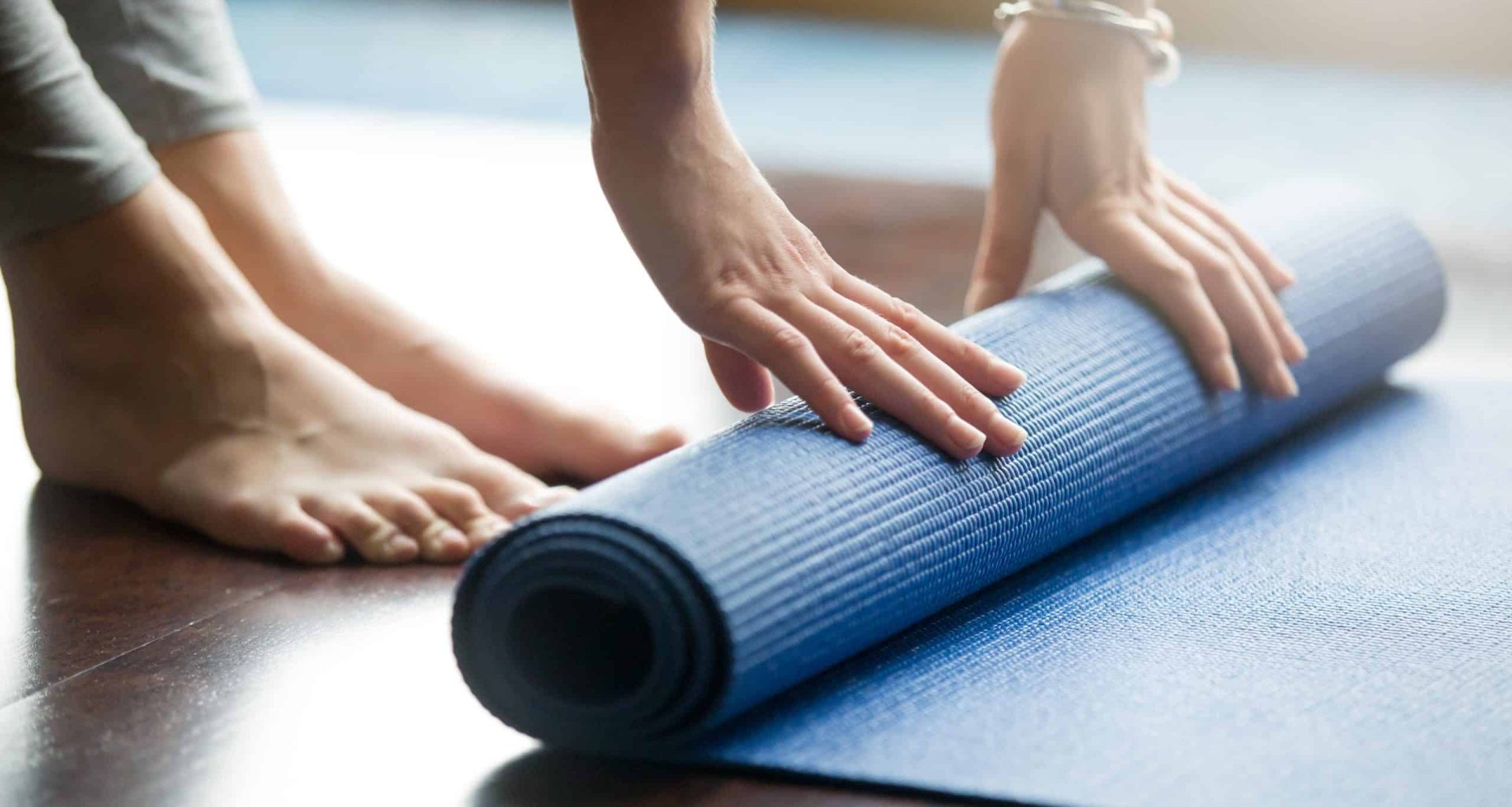 a person rolling a yoga mat